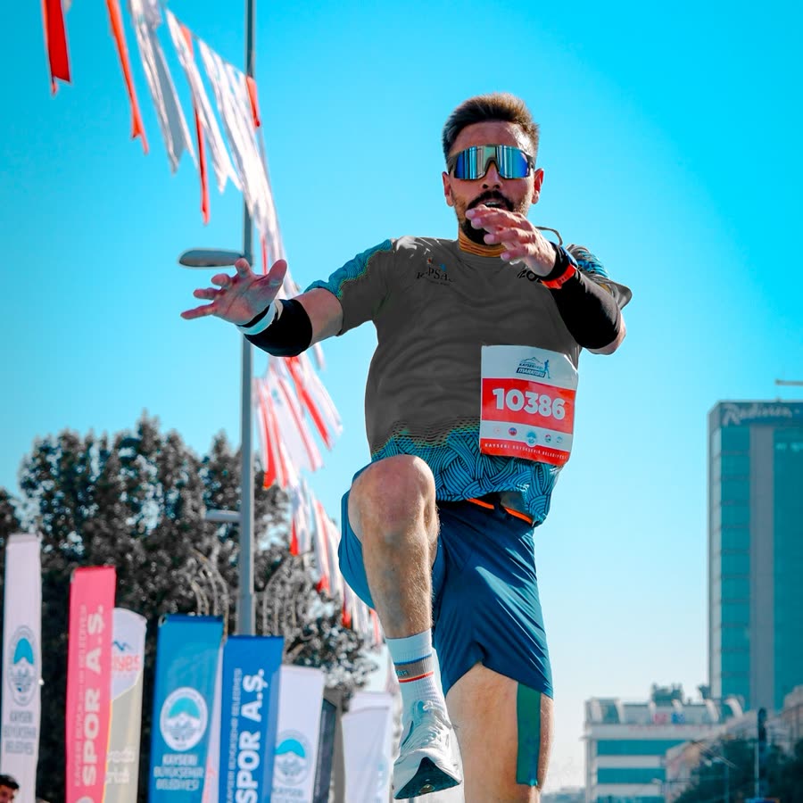 רץ באוויר בתחרות ריצה עירונית, על רקע דגלוני מסלול